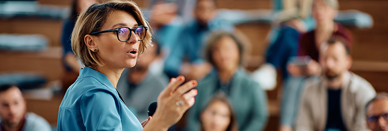 we can see a women leader addressing a croud and talking in a mic